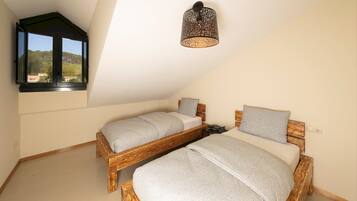 Un dormitorio con dos camas de madera, un tragaluz y una lámpara decorativa en el techo.