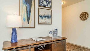 A wooden desk with a lamp, framed abstract paintings, a clock, and a motivational quote sign. - Sunshine Terrace 2BR, perfect for business travel! (Amarillo)