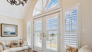 A living room with a sofa, a rug, and a painting on the wall. - Short drive to Downtown Cambridge | Private Dock | Guest House | Pool | Hot Tub (Cambridge)