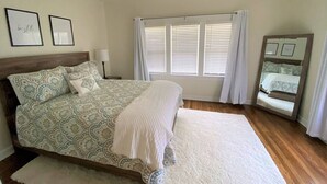 A bedroom with a large bed, a ceiling fan, and a window with blinds. - Urban Hideaway - Cozy & Remodeled 2 BR! (Amarillo)