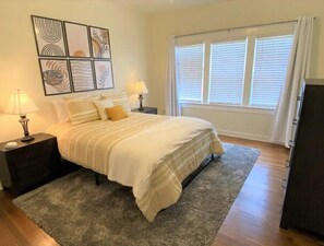 Cozy retreat with a large bed, bedside tables, and framed artworks.