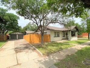 Set amidst a lush lawn, this two-story house offers a garage and a separate storage area.