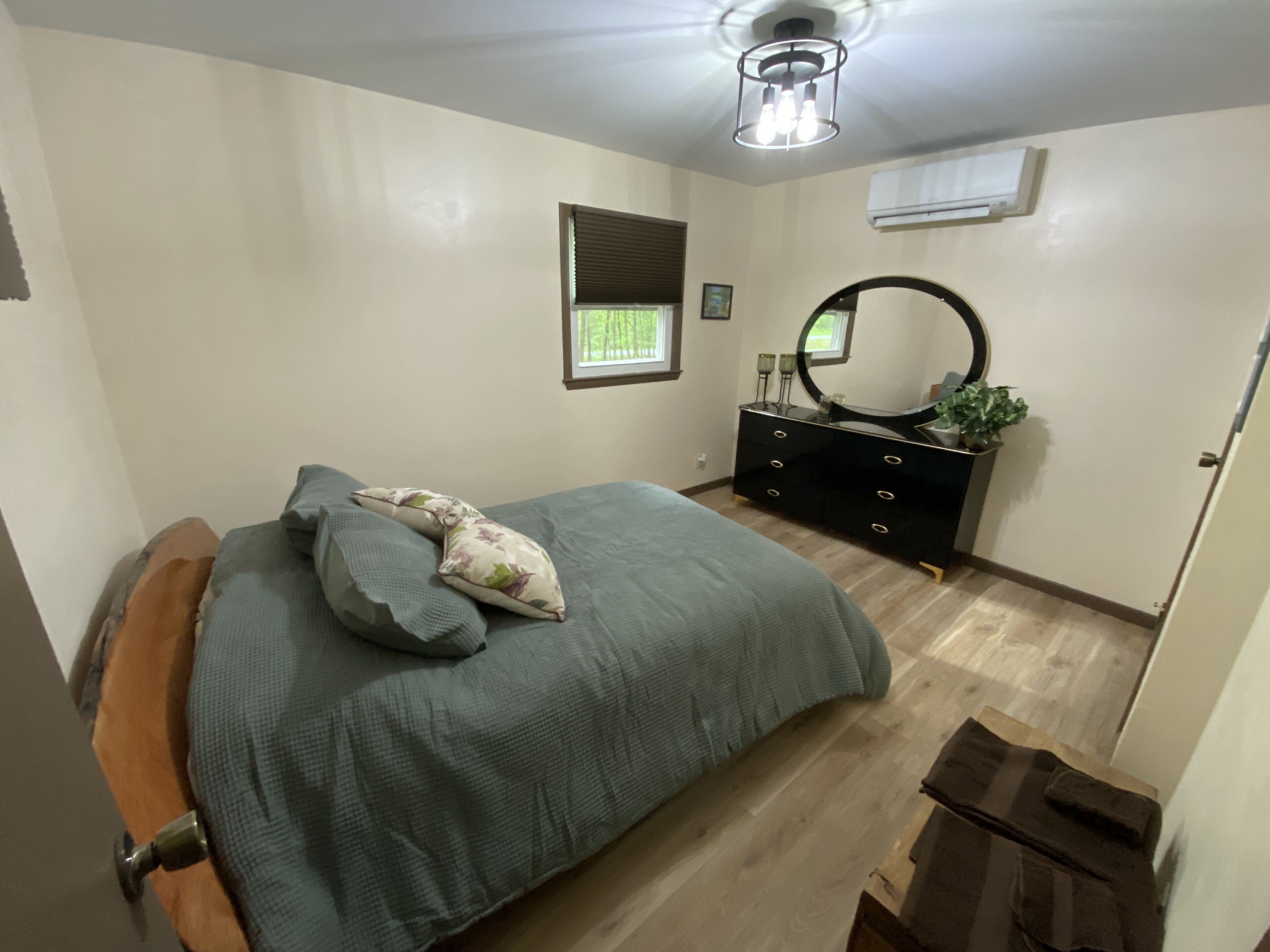Un dormitorio con cama, cómoda y espejo.