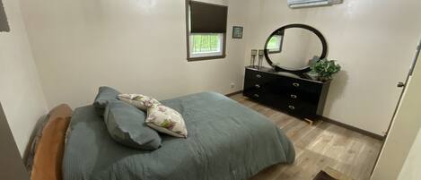 Un dormitorio con cama, cómoda y espejo.