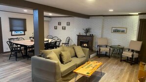 Una sala de estar con sofá, mesa de centro, chimenea y comedor con sillas y una mesa.