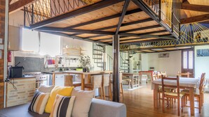 A spacious living area with a sofa, dining table, and chairs. A kitchen with modern appliances is visible in the background. - Aura - Apartment for 8 persons in renovated Couvent les Ursulines, Pézenas (Pézenas)
