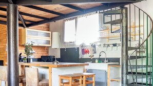 A kitchen with wooden flooring, a central island, bar stools, and a spiral staircase. - Aura - Apartment for 8 persons in renovated Couvent les Ursulines, Pézenas (Pézenas)