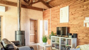 A cozy living room with a fireplace, wooden walls, a sofa, a coffee table, and a bookshelf. - Aura - Apartment for 8 persons in renovated Couvent les Ursulines, Pézenas (Pézenas)