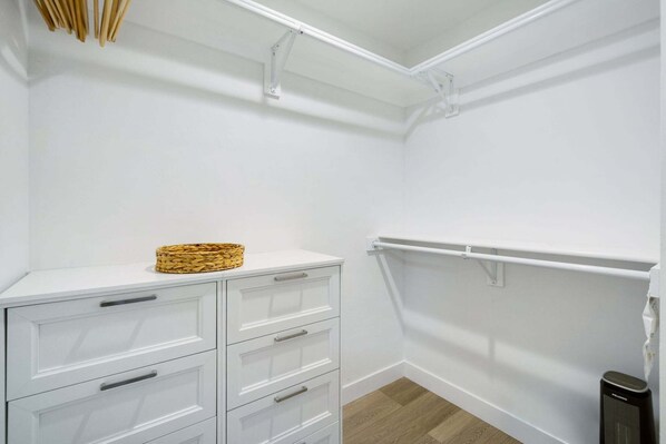 A white closet with a wicker basket on the top shelf, a white dresser with drawers, and a white radiator. - Sunset Views & Beach Days | Tower 9 Across from the Ocean (Oceanside)