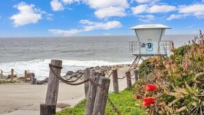 A lifeguard tower with the number 9, overlooking the ocean. - Oceanview Escape | Tower 9 Condo Steps from the Beach (Oceanside)