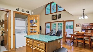 A spacious kitchen with wooden cabinets, a built-in island, and a dining area with wooden chairs and a table. - Clean One Bedroom plus Loft Bedroom Two Bath Cottage with Wi-Fi & Pool Access. (Townsend)