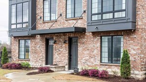 A two-story brick building with large windows and a dark entrance door. - Sky's the Limit (Atlanta)