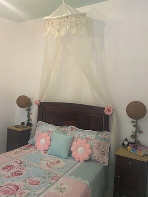 A bedroom with a canopy bed, floral bedding, two nightstands with decorative items, and a wooden headboard. - Casal dos Carpinteiros 5 (Silveira)
