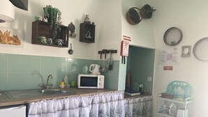 Une cuisine équipée d’un four à micro-ondes, d’un évier et de divers ustensiles de cuisine.