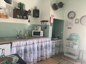 Eine Küche mit Mikrowelle, Spüle und verschiedenen Küchengeräten.