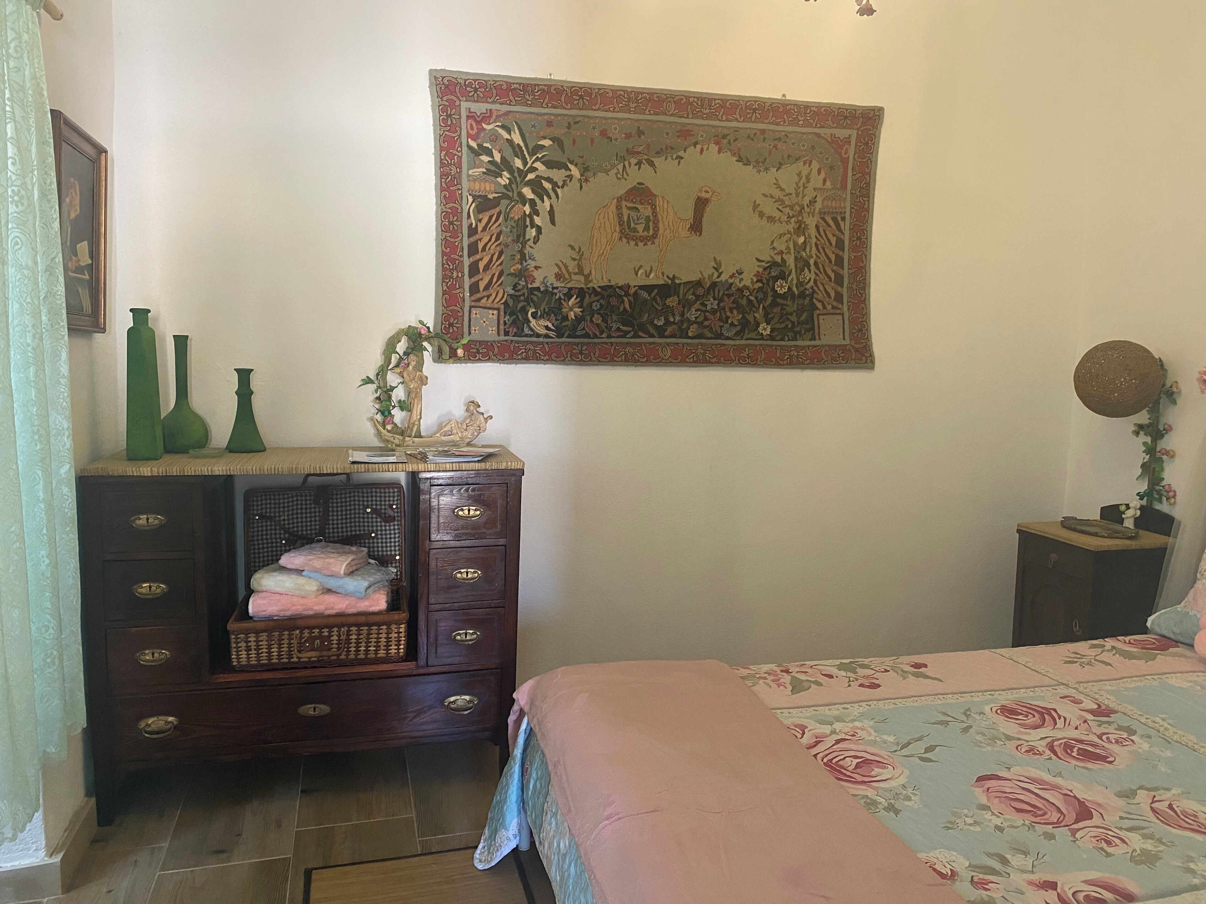 Ein Schlafzimmer mit einem Bett, einem Schminktisch und einer Wandteppich.