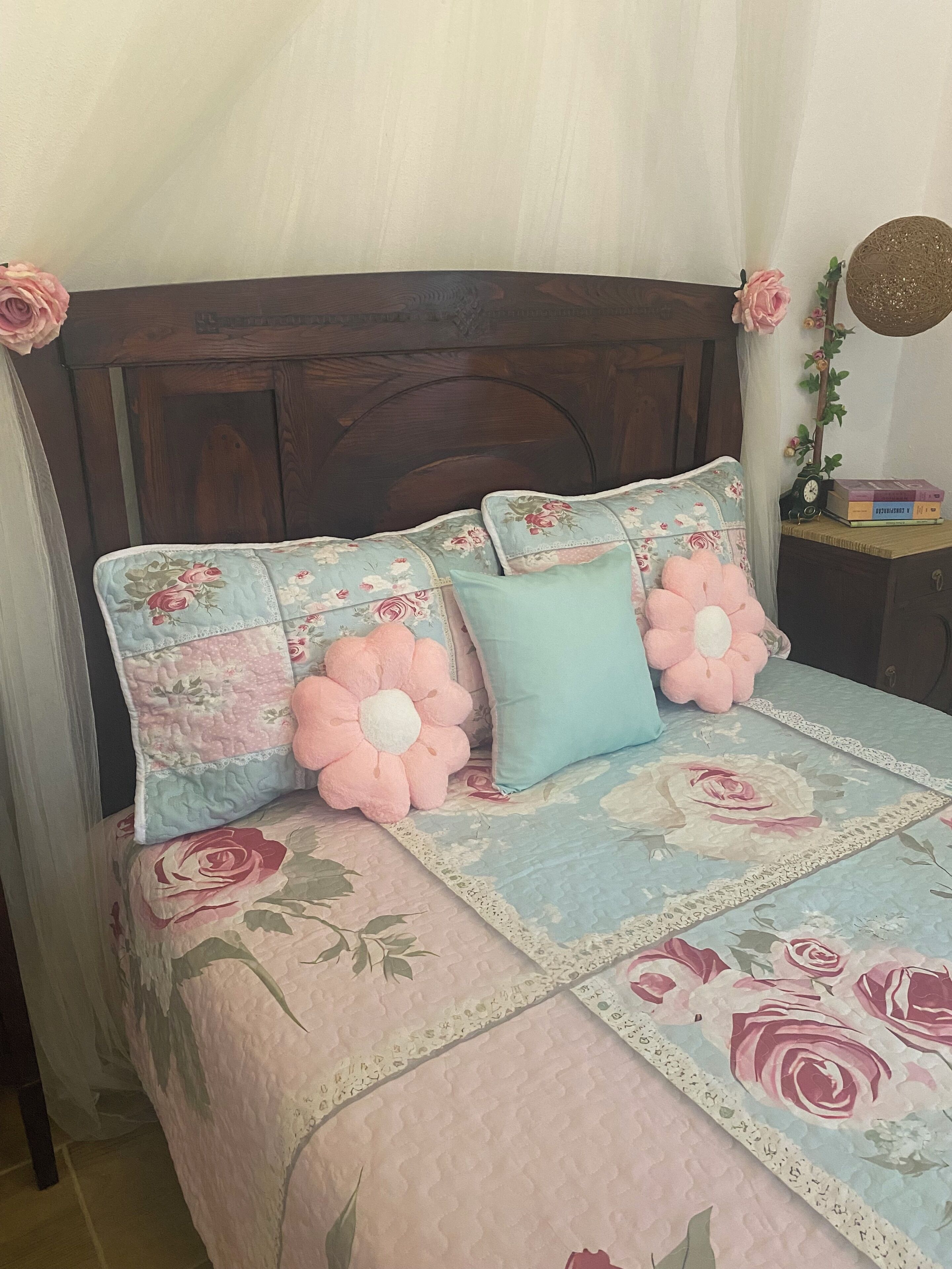 A bed with floral bedding and a wooden headboard.