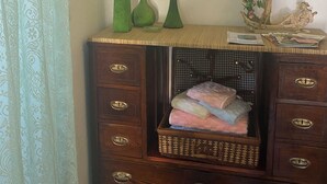 A wooden dresser with drawers, a wicker basket, and a mirror with a decorative frame.