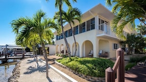A coastal hotel with a large balcony, palm trees, and a view of the water. - Fabulous Island Getaway! Easy access to Florida Bay, Private Beach,  Elevator (Islamorada)