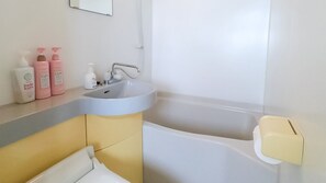 A bathroom with a sink, mirror, and toiletries. - Hotel Olive (Ishigaki)