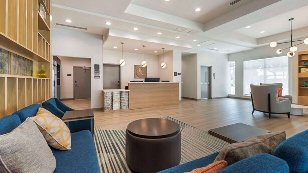 A spacious hotel lobby with a reception desk, seating area with sofas, and a large window providing natural light. - Comfort Suites St. Augustine Historic District Area (St. Augustine)
