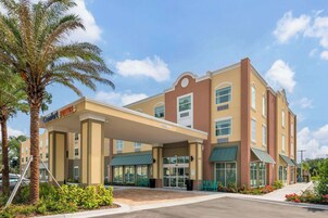 Un hotel con ingresso coperto, diversi piani e un cartello che indica 'Comfort Suites'.