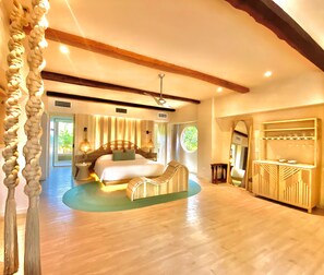 A spacious bedroom with a large bed, a sitting area, and a vanity with a mirror. - Hotel Shibari Tulum (Tulum)