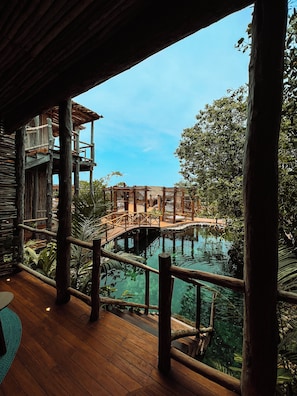 A wooden deck with a view of a pool and a bridge. - Hotel Shibari Tulum (Tulum)