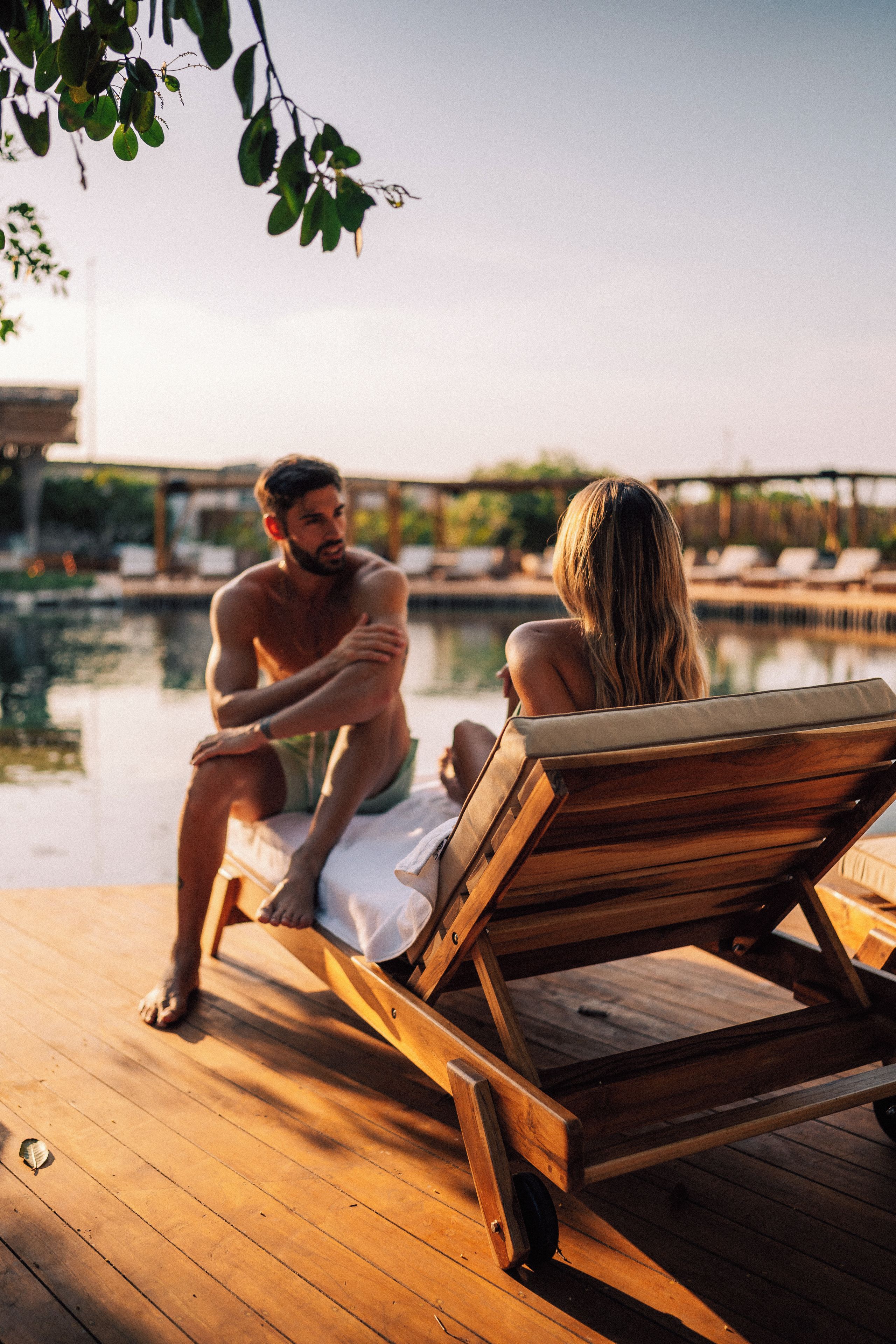 A wooden deck with lounge chairs and a pool.