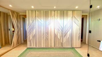 A room with a large sliding door, a green rug, and a glass partition.