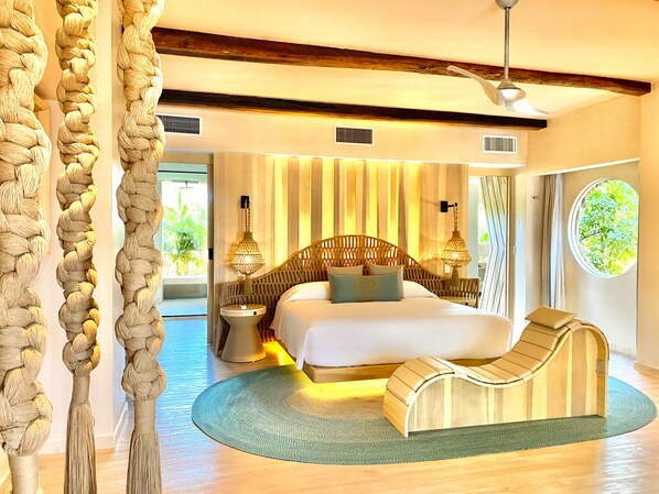 A bedroom with a bed, bedside tables, a reading chair, a window with a view, and a ceiling fan. - Hotel Shibari Tulum (Tulum)