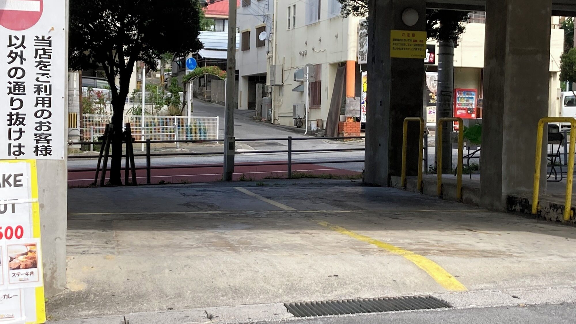 Une vue de rue avec un passage piéton, une enseigne avec du texte en japonais et un bâtiment en arrière-plan.