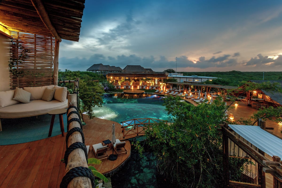 A resort with a pool, lounge chairs, and a wooden deck.