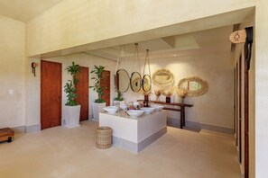 A modern bathroom with a central island, multiple mirrors, and decorative wall elements.