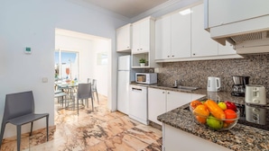 A modern kitchen with white cabinets, granite countertops, and a fruit bowl. - Villa Siesta by Villa Plus (Puerto del Carmen)
