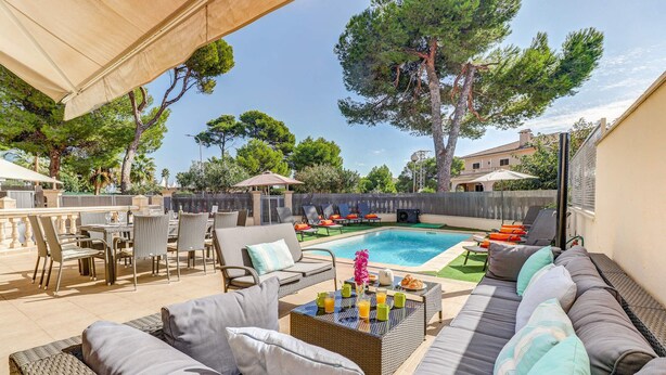 A backyard with a pool, outdoor furniture, and a dining area. - Villa Isabella by Villa Plus (Mallorca)