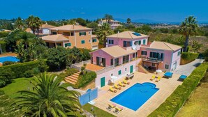 A large, multi-story house with a swimming pool, surrounded by lush greenery and palm trees. - Villa Daisy by Villa Plus (Lagos)