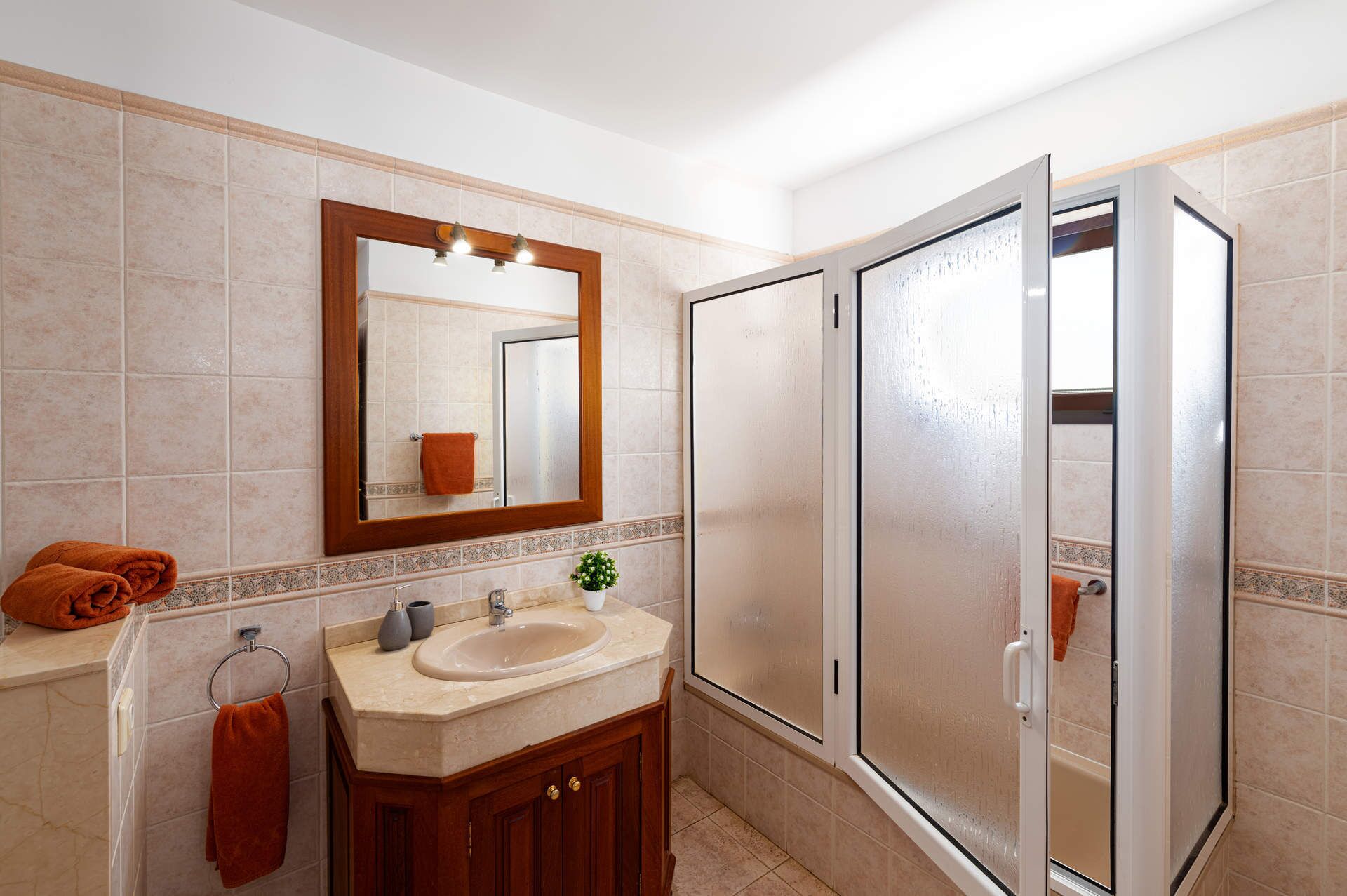 Ein modernes Badezimmer mit Waschbecken, Spiegel und Dusche.