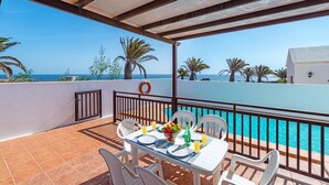 A terrace with a table set for two, overlooking a pool and the sea. - Villa San Marcial by Villa Plus (Tías)