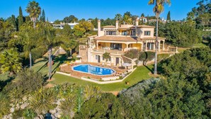A large, two-story house with a swimming pool surrounded by lush greenery. - Villa Racanda by Villa Plus (Carvoeiro)