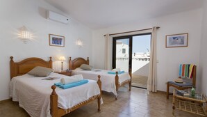 Ein Hotelzimmer mit zwei Holzbett, einem Balkon und Meerblick.