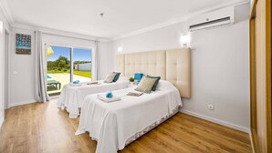 A hotel room with two beds, a large window, and an air conditioning unit. - Villa Citrinos by Villa Plus (Almansil)