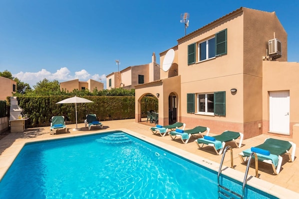 A swimming pool with lounge chairs and a barbecue grill. - Villa Sans Bosch by Villa Plus (Ciutadella de Menorca)
