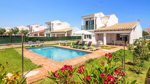 A residential property with a swimming pool, a covered patio, and a garden.