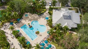 An aerial view of a resort with a central swimming pool, surrounded by palm trees and lounge areas. - Lely Greenlinks 2nd Floor - on Golf Course, Minutes from Beaches, Downtown! (Naples)