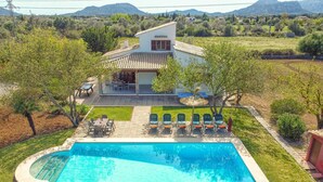 A house with a swimming pool, outdoor seating, and a view of the surrounding landscape. - Villa Mari Pollensa by Villa Plus (Mallorca)