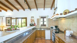 A kitchen with wooden cabinets, a dishwasher, a microwave, and a coffee maker.
