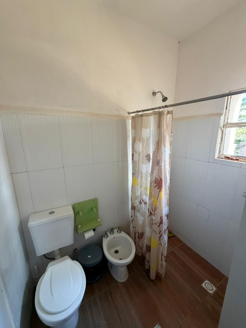 Casa de banho com sanita, bidé e cortina de chuveiro.