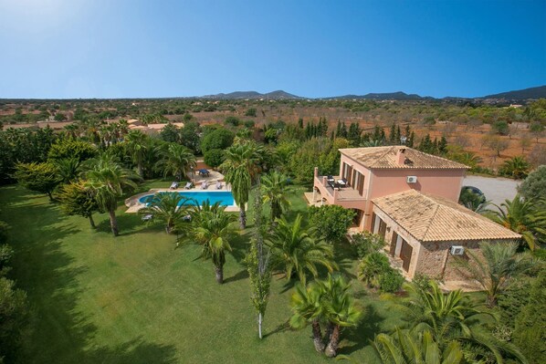 A large house with a swimming pool surrounded by palm trees and a well-maintained lawn. - Villa Marino by Villa Plus (Santañy)