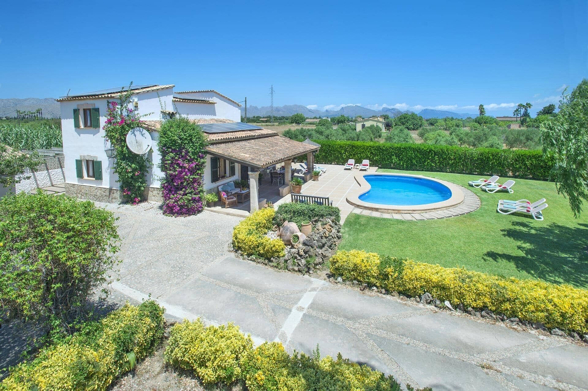 Une villa avec piscine, un patio et vue sur les montagnes.
